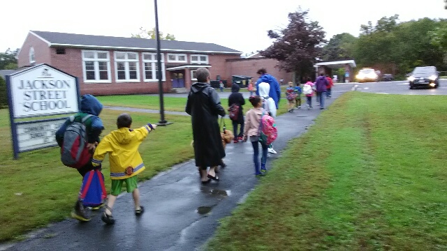 Photo of Gwen walking in the rain with children