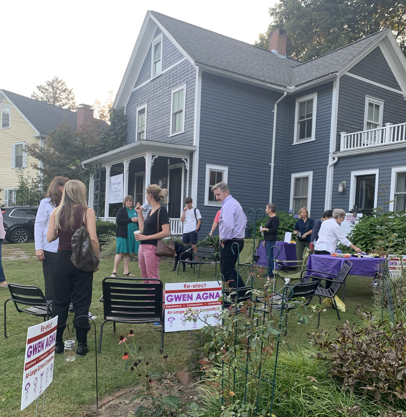 people gathered outside for the event, gwen's signs in the yard.
